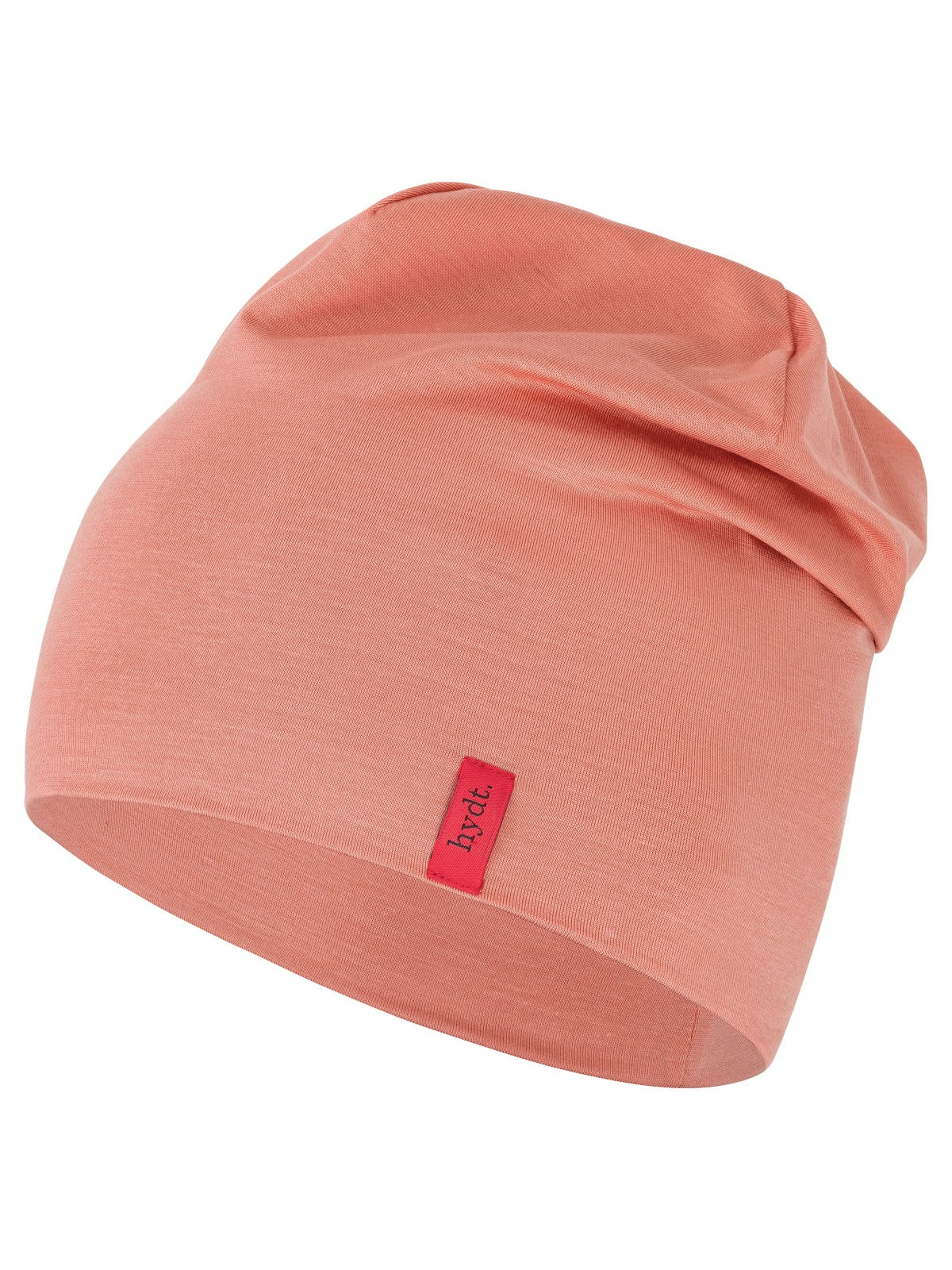 Korallenrote Chemo-Mütze (Beanie) der Marke hydt. aus weichem Jerseymaterial, leicht gerafft fallend mit rotem Marken-Label an der Seite.