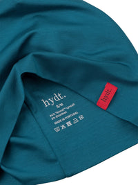 Detailaufnahme der Innenseite der petrolfarbenen hydt. Mütze zeigt das gedruckte kratzfreie Transferlabel: Made in Portugal und Pflegehinweisen.